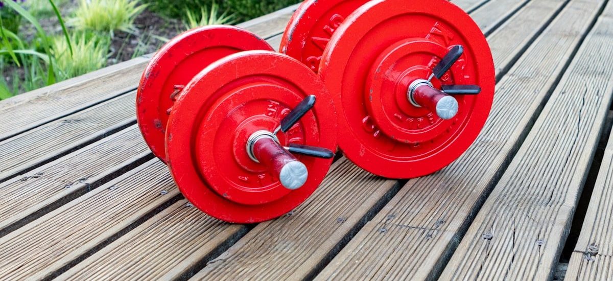 two red dumbbells sitting on a wooden table