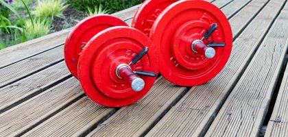 two red dumbbells sitting on a wooden table