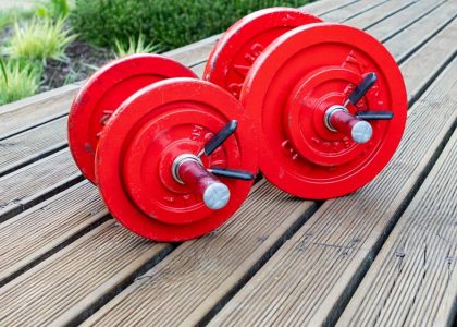 two red dumbbells sitting on a wooden table